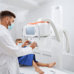 Radiologo tomando Rayos X a paciente